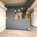 キッチンカウンターの黒いアクセントクロスと木目天井のコーディネート