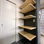 キッチン背面のパイン集成材と黒いブラケットの造作可動棚