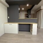 黒いアクセントクロスに馴染むベージュ塗装の造作可動カウンター家具