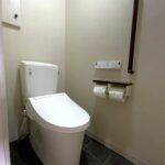 江東区のマンションで行ったジャパンディスタイルのトイレリフォーム完成後の全景写真。LIXILアメージュ便器とグレージュの壁紙、黒を効かせたスタイリッシュな内装。
