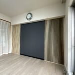 黒アクセントクロスに映える縦格子の造作壁面とペールグレーの床。