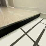 シルバーの細い金属見切りとブラック塗装の立ち上がりで仕上げた特注上がり框。